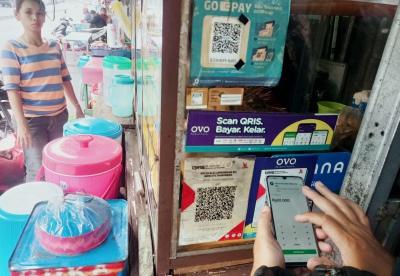 Pembeli menggunakan fitur QRIS di salah satu warung makanan di kawasan Persada Kuningan Raya, Jakarta, Sabtu (27/5/2023).
