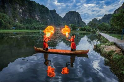 Dua penari Pepe Ri Makka beraktraksi di atas sampan sambil menyemburkan api dan difoto oleh sejumlah fotografer.