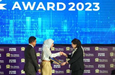 Corporate Secretary SIG Vita Mahreyni (tengah) menerima penghargaan dari Komisaris Bisnis Indonesia Dorothea Samola (kanan).