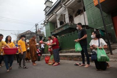 Sejumlah warga memberikan persembahan kepada biksu dalam prosesi Pindapata di Jalan Sulawesi, Kota Makassar, Sulawesi Selatan, Minggu (4/6/2023). 