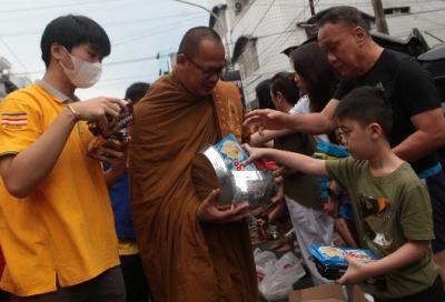 Sejumlah warga memberikan persembahan kepada biksu dalam prosesi Pindapata di Jalan Sulawesi, Kota Makassar, Sulawesi Selatan, Minggu (4/6/2023). 