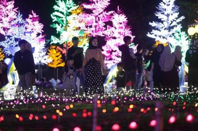 Warga menikmati warna-warni cahaya di area Makassar Light Festival Lapangan Hasanuddin, Makassar, Sulawesi Selatan, Minggu (11/6/2023).