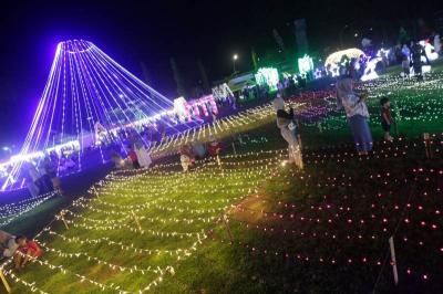 Warga menikmati warna-warni cahaya di area Makassar Light Festival Lapangan Hasanuddin, Makassar, Sulawesi Selatan, Minggu (11/6/2023).