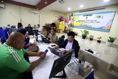 Petugas membantu orang tua murid dan calon peserta didik baru melakukan pengecekan status pendaftaran Penerimaan Peserta Didik Baru (PPDB)