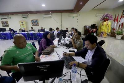 Petugas membantu orang tua murid dan calon peserta didik baru melakukan pengecekan status pendaftaran Penerimaan Peserta Didik Baru (PPDB)