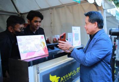 Direktur Utama BSI Hery Gunardi bertransaksi menggunakan QRIS saat berbelanja produk UMKM rekanan BSI Area Malang.