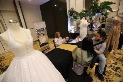 Pengunjung melihat bermacam busana pengantin dan berkonsultasi di stan pameran Menara Danareksa Wedding Expo 2023, di Aryanusa Ballroom, Menara Danareksa.