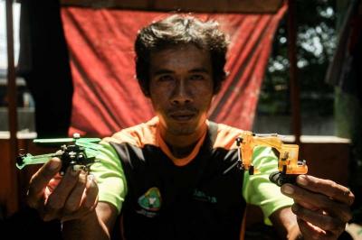 Timan memanfaatkan limbah korek api gas untuk dijadikan kerajinan tangan miniatur di Pos UPS Badan Air Kali Utan Kayu