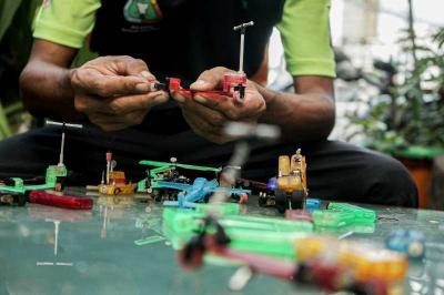 Timan memanfaatkan limbah korek api gas untuk dijadikan kerajinan tangan miniatur di Pos UPS Badan Air Kali Utan Kayu.