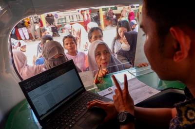 Warga antusis menyambut kehadiran layanan Mobile Customer Services (MCS) BPJS Kesehatan di Kalurahan Tamangapa, Makassar, Sulawesi Selatan, Selasa (8/8/2023).