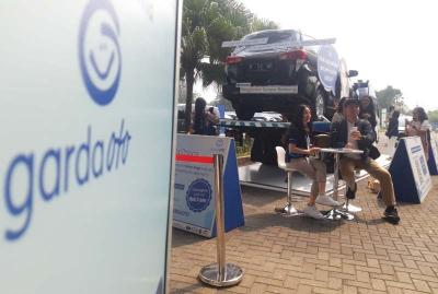 Pengunjung berada di booth Garda Oto di area Gaikindo Indonesia International Auto Show (GIIAS) 2023 di ICE BSD, Tangerang, Banten, Selasa (15/8/2023).