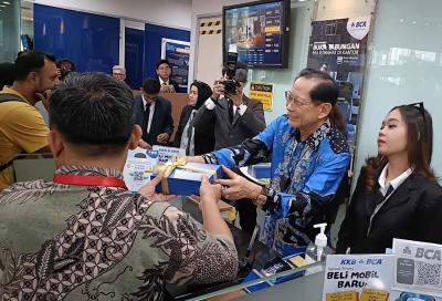 Presiden Direktur BCA Jahja Setiaatmadja menyerahkan cenderamata kepada nasabah di BCA KCU City Tower, Jakarta, Senin (4/9/2023).