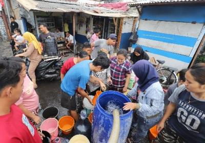 Warga antre mengambil bantuan air bersih di Jalan Utan Jati, RT006 dan RT007, RW011, Kelurahan Pegadungan, Kecamatan Kalideres, Jakarta Barat