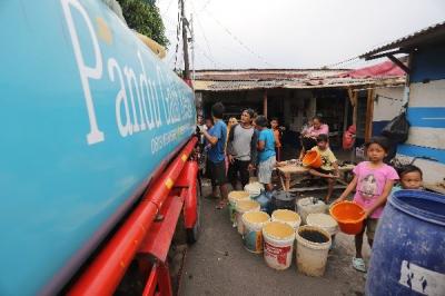 Warga antre mengambil bantuan air bersih di Jalan Utan Jati, RT006 dan RT007, RW011, Kelurahan Pegadungan, Kecamatan Kalideres, Jakarta Barat