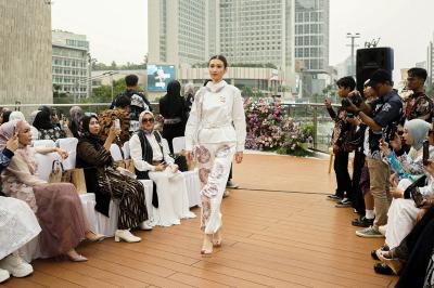 Model memperagakan busana batik karya kolaborasi Batik Trusmi X La Sabelle di Halte TransJakarta Tosari, Jakarta, Senin (2/10/2023).