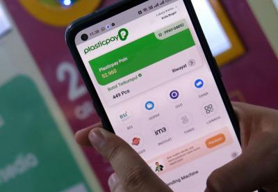 Pengunjung menukarkan sampah plastik dengan pulsa dari operator seluler IM3 dan Tri melalui Reverse Vending Machine (RVM) Plasticpay, di Bogor Trade Mall (BTM)