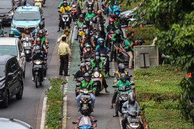 Pengendara ojek online melintas di kawasan Sudirman, Jakarta, Senin (23/10/2023).