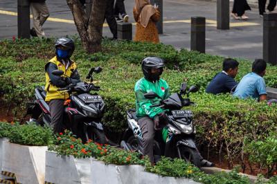 Pengendara ojek online melintas di kawasan Sudirman, Jakarta, Senin (23/10/2023).