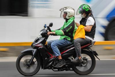 Pengendara ojek online melintas di kawasan Sudirman, Jakarta, Senin (23/10/2023).