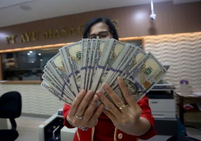Karyawati menunjukkan mata uang rupiah dan dolar Amerika Serikat di tempat penukaran uang asing Agung Masayu di Jakarta, Selasa (24/10/2023).