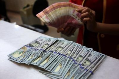 Karyawati menunjukkan mata uang rupiah dan dolar Amerika Serikat di tempat penukaran uang asing Agung Masayu di Jakarta, Selasa (24/10/2023).