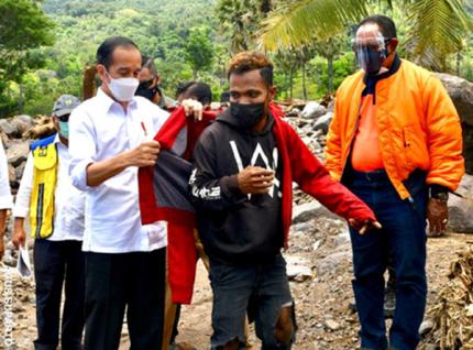 Presiden Jokowi memberikan jaket pribadinya kepada Fransiskus Ade Uran Atawalo, saat mengunjungi Desa Amakaka Kecamatan Ile Ape, Lembata, NTT, Jumat (9/4/2021).