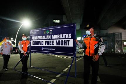 Petugas membawa papan bertuliskan Crowd Free Night di kawasan Blok M, Jakarta Selatan, Jumat (31/12/2021).