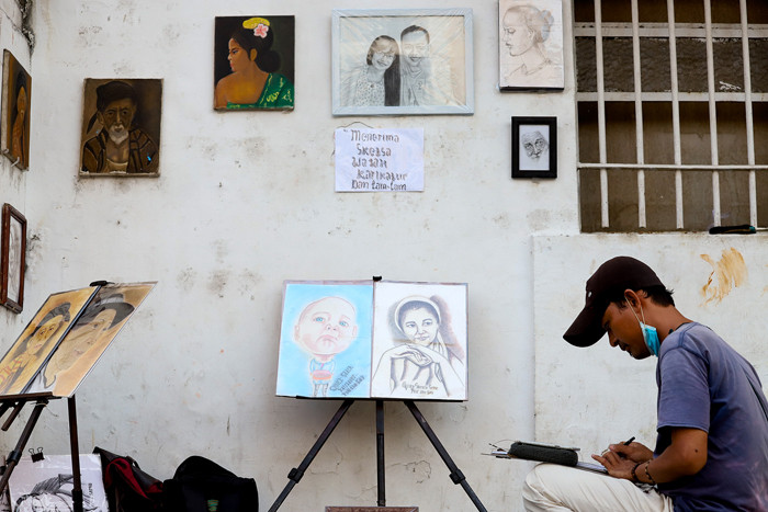 Jasa pembuat sketsa wajah sedang menyelesaikan pesanannya di kawasan Kota Tua, Jakarta Barat, Selasa (6/7/2021).