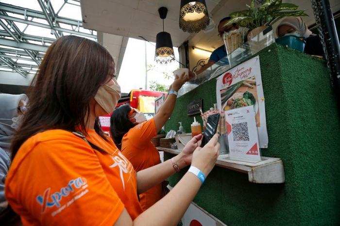Pengunjung BNI Loud Fest tengah berbelanja menggunakan BNI Mobile Banking di Jakarta Convention Center, Minggu (17/7/2022).
