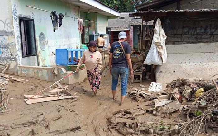 Warga kesulitan membersihkan rumah karena lumpur tebal akibat banjir yang menerjang wilayah Bekasi, Jawa Barat (Foto: Jonathan Simanjuntak/MPI)