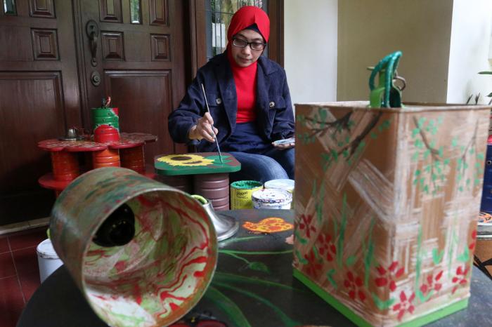 Perajin menyelesaikan pembuatan pot bunga dari kaleng bekas