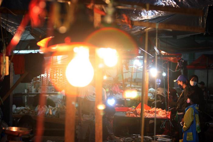 Pedagang dan pembeli beraktivitas di Pasar Kramat Jati, Jakarta Timur, Sabtu (27/2/2021) malam.