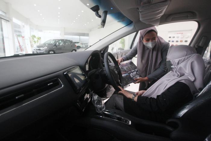 Petugas memberikan penjelasan kepada calon pembeli di Honda Mitra Jatiasih, Kota Bekasi, Jawa Barat, Senin (1/3/2021).