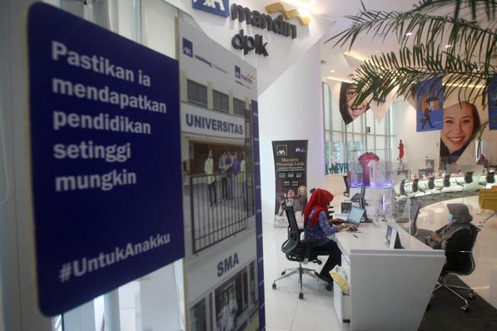 Petugas melayani nasabah di Kantor Pusat AXA Mandiri, Jakarta