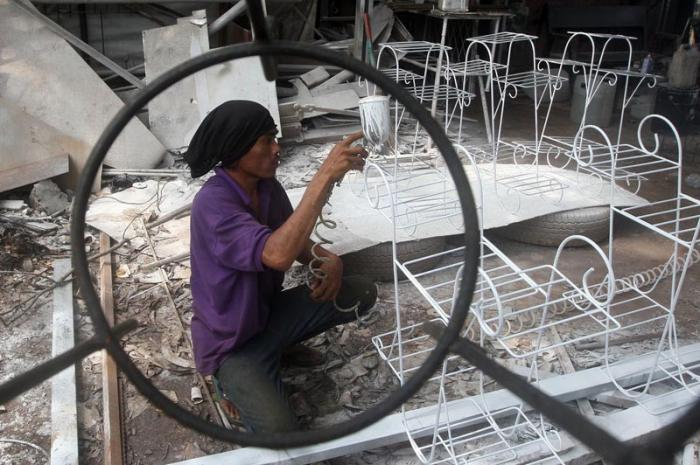 Pekerja sedang menyelesaikan pembuatan rak pot bunga dari besi di kawasan Jalan Kodau, Kota Bekasi, Jawa Barat, Jumat (5/3/2021).