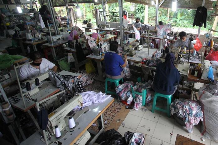Penjahit menyelesaikan pembuatan baju di sebuah usaha konfeksi milik Enca di Curug, Bogor