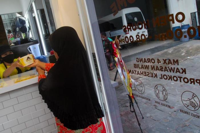 Pembeli dengan aturan protokol kesehatan memesan makanan berbahan baku daging di gerai kuliner kawasan Rawasari Selatan, Jakarta Pusat