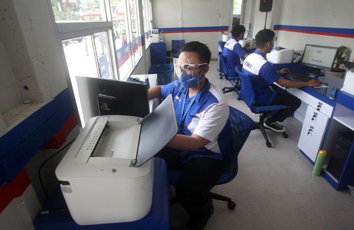 Petugas melayani nasabah untuk melakukan transaksi pengiriman arsip di Jakarta, Rabu (17/3/2021).