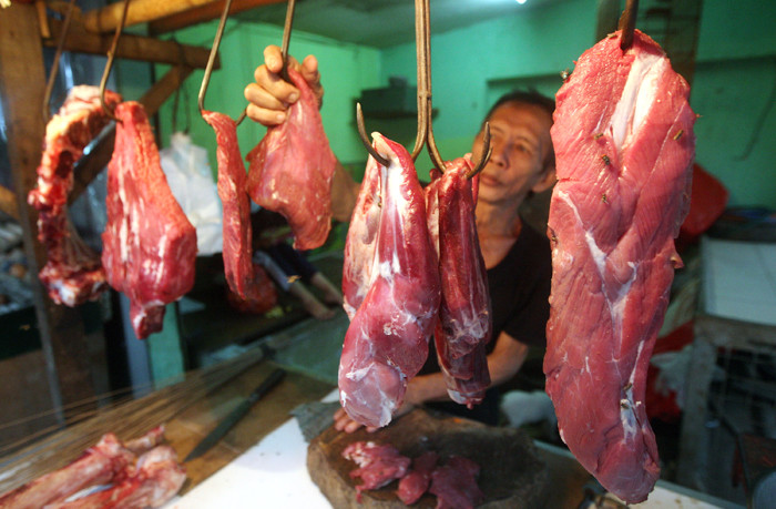 Pedagang daging merapikan dagangannya di Pasar Kecapi, Kota Bekasi, Jawa Barat, Kamis (18/3/2021).