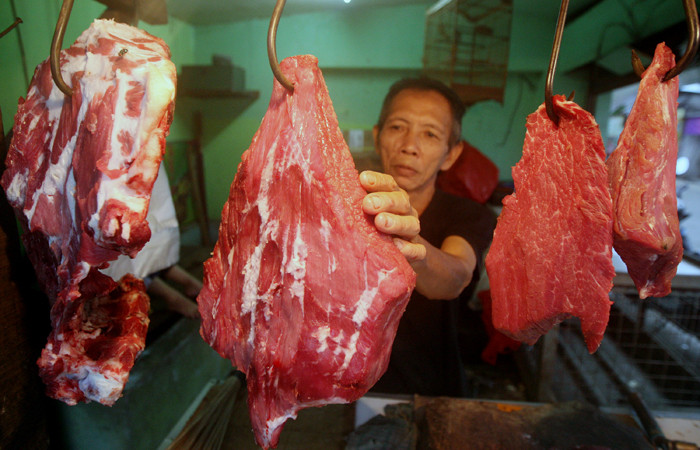 Pedagang daging merapikan dagangannya di Pasar Kecapi, Kota Bekasi, Jawa Barat, Kamis (18/3/2021).