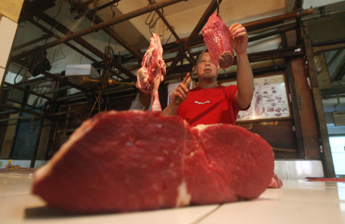 Pedagang memotong daging di Pasar Kramat Jati, Jakarta Timur, Selasa (23/3/2021).