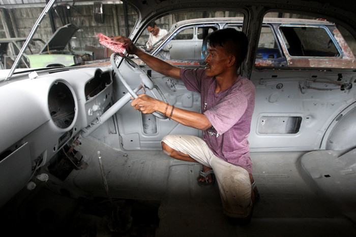 Warga menyelesaikan pembuatan mobil klasik di Gas+ Auto Engineering di kawasan Kranggan, Kota Bekasi, Jawa Barat, Rabu (24/3/2021).