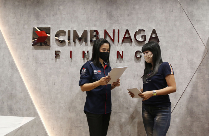 Karyawan melayani nasabah di kantor PT CIMB Niaga Auto Finance (CNAF) di kawasan Bintaro, Tangerang Selatan, Banten, Jumat (26/3/2021).
