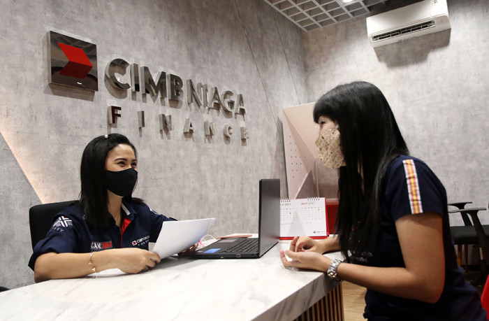 Karyawan melayani nasabah di kantor PT CIMB Niaga Auto Finance (CNAF) di kawasan Bintaro, Tangerang Selatan, Banten, Jumat (26/3/2021).