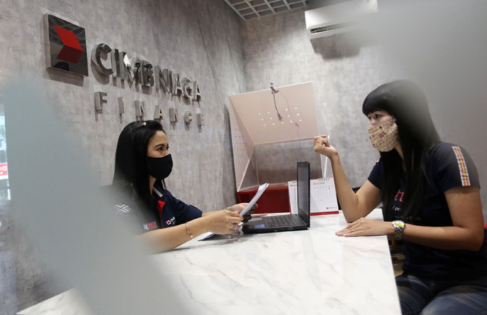 Karyawan melayani nasabah di kantor PT CIMB Niaga Auto Finance (CNAF) di kawasan Bintaro, Tangerang Selatan, Banten, Jumat (26/3/2021).