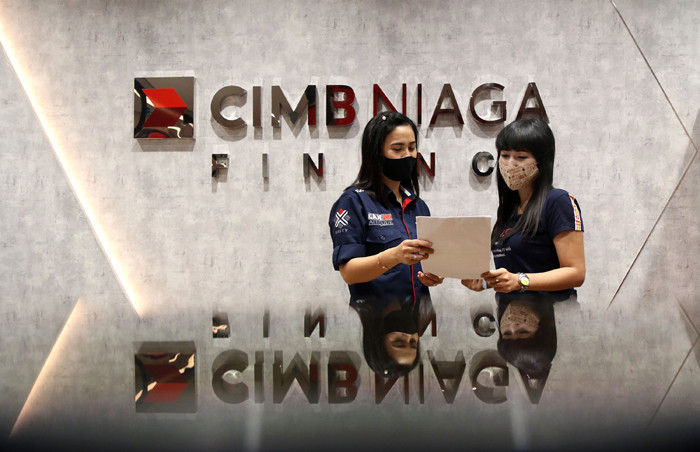 Karyawan melayani nasabah di kantor PT CIMB Niaga Auto Finance (CNAF) di kawasan Bintaro, Tangerang Selatan, Banten, Jumat (26/3/2021).