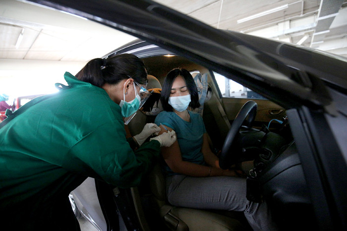 Petugas medis menyuntikan vaksin kepada lansia secara drive thru di Rumah Sakit Universitas Indonesia, Depok, Jawa Barat, Kamis (25/3/2021).