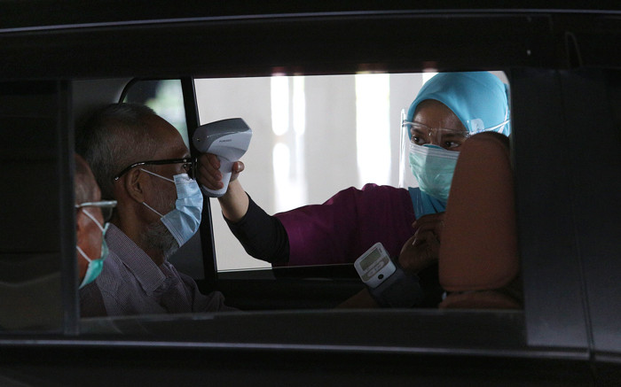 Petugas medis menyuntikan vaksin kepada lansia secara drive thru di Rumah Sakit Universitas Indonesia, Depok, Jawa Barat, Kamis (25/3/2021).