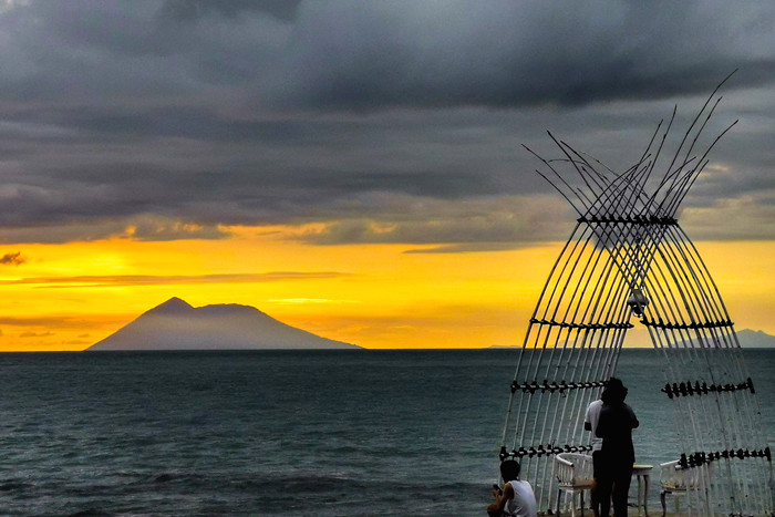 Pengunjung menikmati keindahan panorama matahari terbenam di Pantai Anyer, Serang, Banten, Sabtu (27/3/2021).