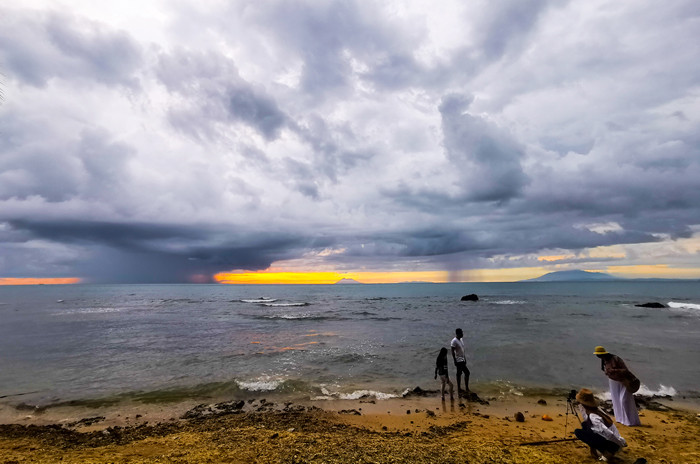 Pengunjung menikmati keindahan panorama matahari terbenam di Pantai Anyer, Serang, Banten, Sabtu (27/3/2021).